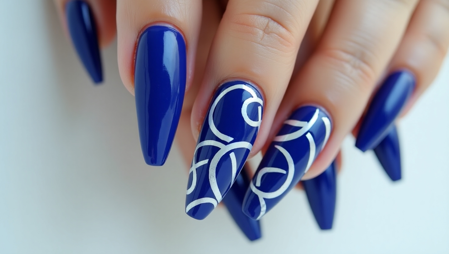 Artsy cobalt blue nails with bold patterns.