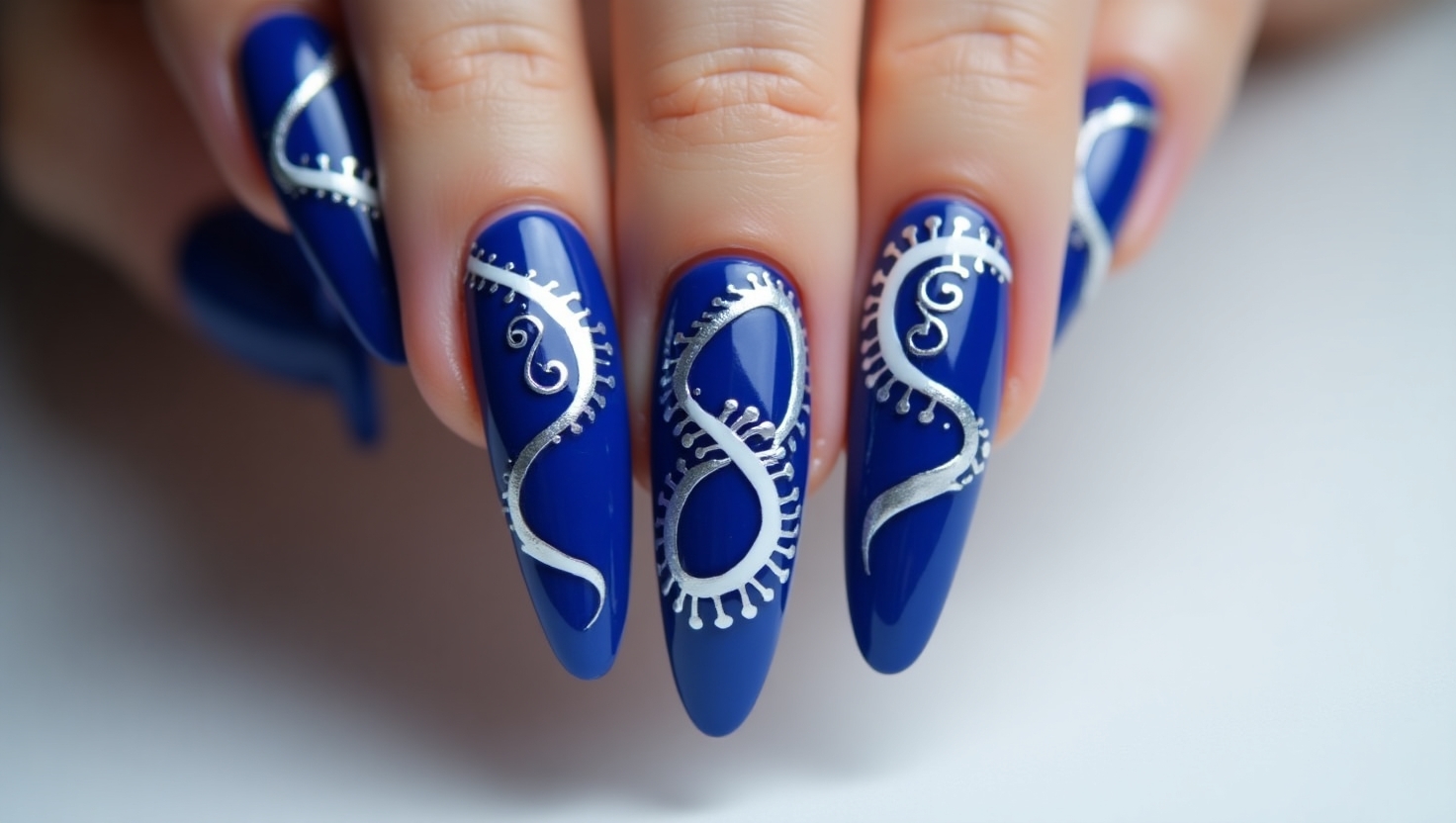 Artsy cobalt blue nails with bold patterns.